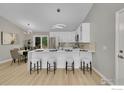Modern kitchen with stainless steel appliances, white cabinetry, and a breakfast bar at 106 S Madison Ave, Louisville, CO 80027