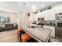 Modern kitchen featuring an island with seating and stainless steel appliances at 1099 Spartan Ave, Berthoud, CO 80513