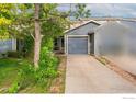Inviting home featuring a driveway leading to an attached garage and a covered porch at 11096 Claude Ct, Northglenn, CO 80233