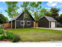 A beautiful home with a detached garage, green lawn, and natural landscaping, providing a serene setting at 133 Placer Ave, Longmont, CO 80504