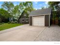 Exterior view of a gray garage with white door and concrete driveway, offering ample parking space at 133 Placer Ave, Longmont, CO 80504
