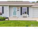 Home with a charming front porch that includes a bench, flowers, and views of the well maintained front lawn at 13441 Sheridan Blvd, Broomfield, CO 80020