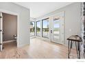 Bright entryway with large windows, white trim, modern door and light wood floors at 1563 Spring Creek Xing, Lafayette, CO 80026