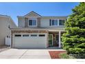 Charming two-story home featuring stone accents, a spacious garage, and a well-manicured yard at 18656 Kelly Pl, Denver, CO 80249
