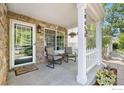 Cozy front porch featuring stone accents, seating, and a welcoming entrance at 18656 Kelly Pl, Denver, CO 80249