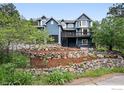 Charming blue two-story home with a deck, rock terraced garden, and mature trees at 1946 Lefthand Canyon Dr, Boulder, CO 80302