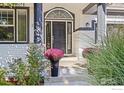 Elegant front entrance with a modern front door and vibrant flower accents at 2001 Coralbells Ct, Longmont, CO 80503