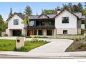 Elegant home with stone and black trim, showcasing the driveway, yard and front facade at 2100 Kohler Dr, Boulder, CO 80305