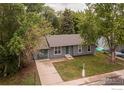 Bird's eye view of a charming home surrounded by lush greenery, garage and driveway at 2230 Lincoln St, Longmont, CO 80501