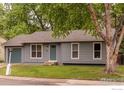 Traditional single-story home featuring a well-manicured front yard and blue door at 2230 Lincoln St, Longmont, CO 80501