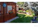 Private backyard featuring a lovely pergola, meticulously maintained garden, and mature trees at 2549 Cowley Dr, Lafayette, CO 80026