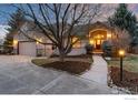 Inviting home featuring a well-manicured lawn, beautiful stone accents and an arched entryway with warm lighting at 2549 Cowley Dr, Lafayette, CO 80026
