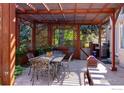 Charming outdoor dining area with a wooden pergola, stylish metal furniture set, and serene garden views at 2549 Cowley Dr, Lafayette, CO 80026