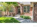 Inviting red-brick home with arched entryway and well-manicured landscaping at 2563 Otter Ct, Lafayette, CO 80026