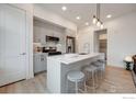Bright kitchen boasts a center island with seating, light gray cabinetry and stainless steel appliances at 2876 W 53Rd Ave # 301, Denver, CO 80221
