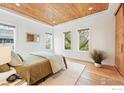 Bright main bedroom featuring natural wood ceiling, hardwood floors, and large windows offering tree views at 2970 21St St, Boulder, CO 80304