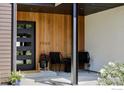 Inviting front porch with modern wood paneling, a black front door and two chairs at 3560 16Th St, Boulder, CO 80304