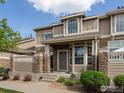 Attractive townhome with stone pillars, covered entry, and well-kept landscaping at 4795 Raven Run, Broomfield, CO 80023