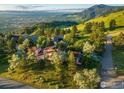 Aerial view of an estate home situated on a lush hillside with mountain views at 495 S Cedar Brook Rd, Boulder, CO 80304