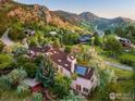 Panoramic aerial shot of an estate home surrounded by lush greenery and mountain views at 495 S Cedar Brook Rd, Boulder, CO 80304