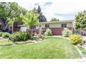 Single-story home with a neatly landscaped front yard and mature trees at 501 Copeland Way, Longmont, CO 80504