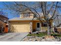 Two-story home with a two-car garage and a cozy front porch surrounded by well-kept landscaping at 5241 E 128Th Way, Thornton, CO 80241