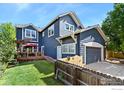 View of home's back exterior featuring a deck, patio and a fenced yard and attached garage at 633 Deerwood Dr, Longmont, CO 80504