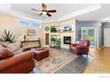 Open-concept living room featuring a fireplace, tray ceiling, and lots of natural light at 633 Deerwood Dr, Longmont, CO 80504