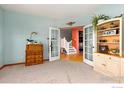 Bright office with a carpeted floor, french doors, built-in shelves, and cheerful wall colors at 633 Deerwood Dr, Longmont, CO 80504