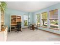 Bright office with a desk, table, chairs, a carpeted floor, built-in shelves, and 3 windows at 633 Deerwood Dr, Longmont, CO 80504