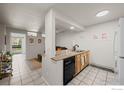 Open floor plan kitchen featuring a breakfast bar with stainless sink and black dishwasher at 1065 University Ave # 121, Boulder, CO 80302