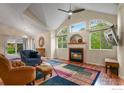 Cozy living room with a fireplace, large windows, and stylish furniture at 1279 Cressida Ct, Lafayette, CO 80026