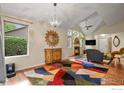 Spacious living room with vaulted ceilings, fireplace, and colorful accent rug at 1279 Cressida Ct, Lafayette, CO 80026
