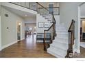 Open foyer with staircase, hardwood floors, and views of the adjacent dining and living areas at 1321 Onyx Cir, Longmont, CO 80504