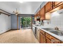 Bright kitchen with wood cabinets, white countertops, an open layout, and sliding glass door to the outdoors at 1380 Ithaca Dr, Boulder, CO 80305