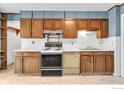 Traditional kitchen features classic cabinetry, white countertops and backsplash, and standard appliances at 1380 Ithaca Dr, Boulder, CO 80305