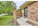 Close-up view of a home's front entrance with a small privacy fence and brick facade with access to the front door at 1510 22Nd Ave, Longmont, CO 80501