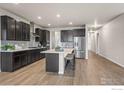 Contemporary kitchen with an island, stainless steel appliances, and stylish lighting fixtures at 1677 Meagan Way, Erie, CO 80516