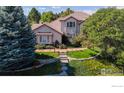 Inviting two-story home with stone accents, lush lawn and garden, and well-lit walkway at 1977 Champions Cir, Castle Rock, CO 80104