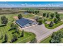 Aerial view showcasing a large barn, fenced pastures, and ample space for equestrian activities in a serene setting at 20360 County Road 3, Berthoud, CO 80513