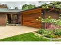 Close-up of a brick house featuring a custom wood garage door and tiled front entrance at 205 Lipan Way, Boulder, CO 80303
