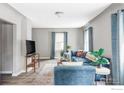 Bright living room featuring a comfortable blue sectional, modern decor, and ample natural light at 2565 Pierce St, Lakewood, CO 80214