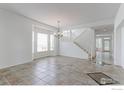 Bright dining area with tile flooring, large windows, and a stylish chandelier at 2631 E 136Th Pl, Thornton, CO 80602