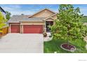 Two-story home with a red two-car garage, landscaped yard, and covered front porch at 2767 Stallion Way, Mead, CO 80542
