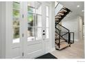 Elegant foyer featuring a modern glass door entrance and a staircase with iron railings at 2860 Table Mesa Dr, Boulder, CO 80305