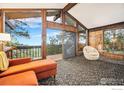 Bright living room with wood paneling, a wall of windows, and access to the outdoors at 335 Wild Horse Cir, Boulder, CO 80304