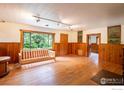 Bright living room featuring wood floors, large windows, and wood paneled walls at 35106 Boulder Canyon Dr, Boulder, CO 80302