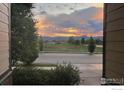 View of a street in a new home community with mountains in the background at sunset at 3572 Lissa Dr, Berthoud, CO 80513