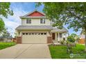 Charming two-story home featuring a two-car garage, well-manicured lawn, and inviting curb appeal at 5023 Goshawk Ct, Brighton, CO 80601