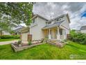 Charming home featuring an attached garage, well-maintained lawn, and mature trees at 5023 Goshawk Ct, Brighton, CO 80601